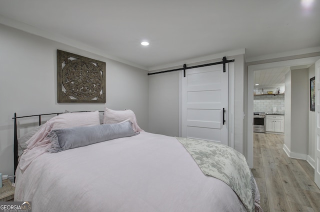 198 Hillcrest Dr, Calhoun, GA 30701 - bedroom featuring a barn door, recessed lighting, and light wood-style flooring