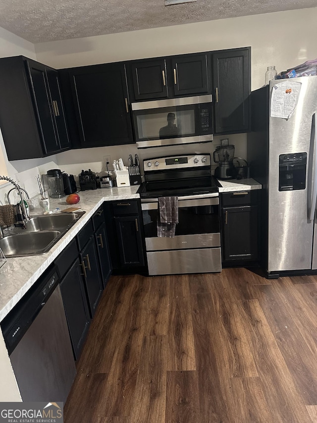 3332 Waldrop Trl, Decatur, GA 30034 - kitchen with appliances with stainless steel finishes, dark cabinetry, light countertops, dark wood-style flooring, and a textured ceiling