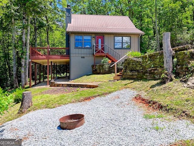 967 Saddle Gap Dr, Clayton, GA 30525 - view of front of house with a chimney, a fire pit, a metal roof, board and batten siding, and a deck