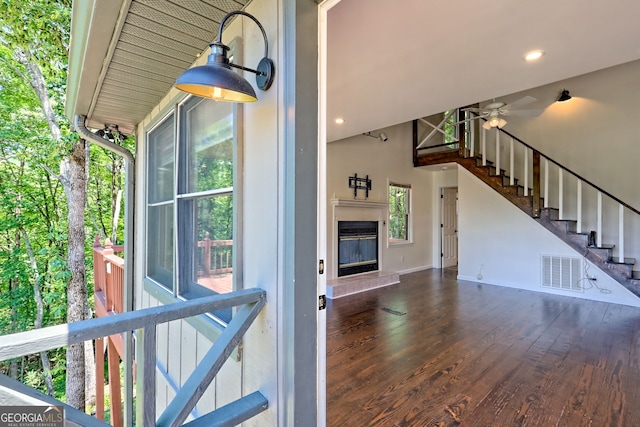 967 Saddle Gap Dr, Clayton, GA 30525 - unfurnished living room with a ceiling fan, wood finished floors, stairs, a glass covered fireplace, and a towering ceiling