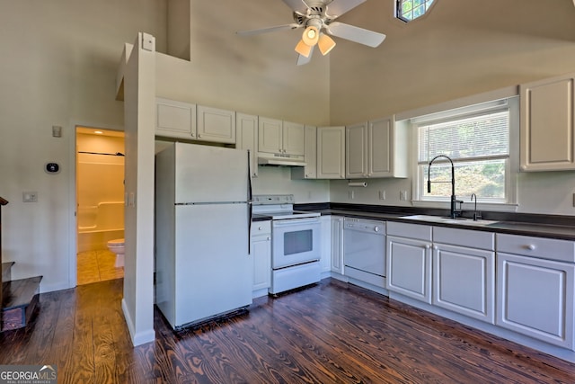 967 Saddle Gap Dr, Clayton, GA 30525 - kitchen featuring white appliances, under cabinet range hood, high vaulted ceiling, dark countertops, and dark wood-type flooring