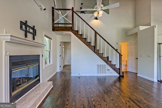 967 Saddle Gap Dr, Clayton, GA 30525 - unfurnished living room featuring a high ceiling, a tiled fireplace, wood finished floors, stairway, and a ceiling fan