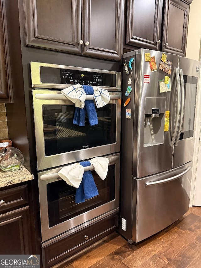 173 Lavender Way, Mcdonough, GA 30252 - kitchen with appliances with stainless steel finishes, dark brown cabinets, dark wood-style flooring, and light stone countertops