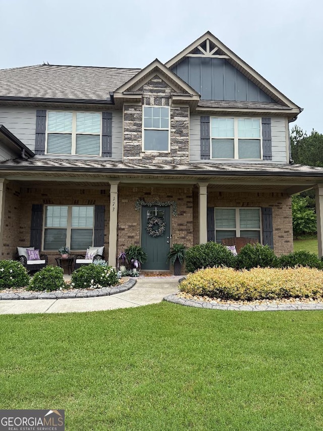 173 Lavender Way, Mcdonough, GA 30252 - view of front of home featuring a front lawn, covered porch, brick siding, and board and batten siding