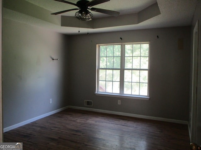 181 Thorpe Rd, Jackson, GA 30233 - empty room featuring dark wood-type flooring, a ceiling fan, a textured ceiling, and a tray ceiling