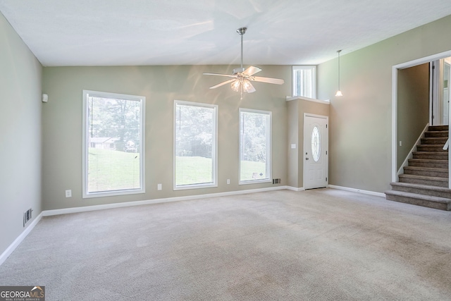 717 Raven Springs Trl, Stone Mountain, GA 30087 - unfurnished living room with light carpet, a ceiling fan, stairway, and vaulted ceiling