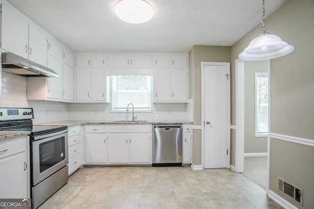 717 Raven Springs Trl, Stone Mountain, GA 30087 - kitchen featuring stainless steel appliances, under cabinet range hood, tasteful backsplash, white cabinets, and plenty of natural light