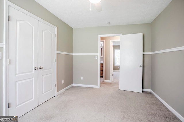 717 Raven Springs Trl, Stone Mountain, GA 30087 - unfurnished bedroom with light colored carpet, a closet, and ceiling fan