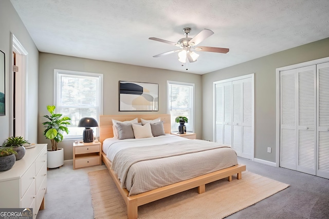 717 Raven Springs Trl, Stone Mountain, GA 30087 - bedroom featuring light carpet, multiple closets, and ceiling fan
