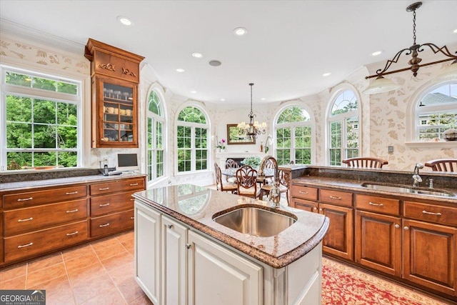 311 N Rivoli Farms Dr, Macon, GA 31210 - kitchen featuring crown molding, an island with sink, hanging light fixtures, a chandelier, and dark stone counters