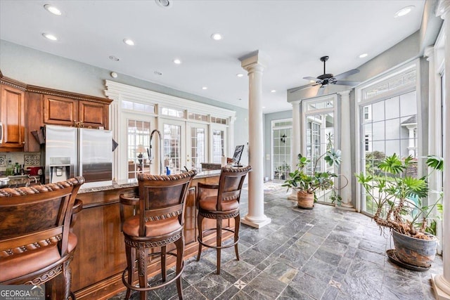 311 N Rivoli Farms Dr, Macon, GA 31210 - kitchen with stainless steel refrigerator with ice dispenser, decorative columns, a ceiling fan, brown cabinets, and recessed lighting