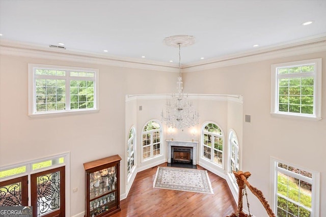 311 N Rivoli Farms Dr, Macon, GA 31210 - living room with ornamental molding, wood finished floors, a towering ceiling, a chandelier, and a fireplace