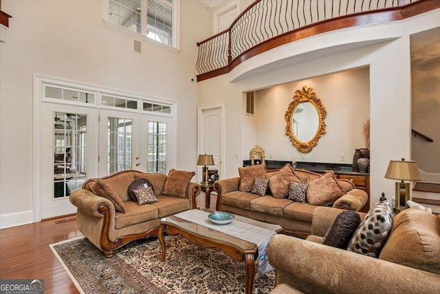 311 N Rivoli Farms Dr, Macon, GA 31210 - living room featuring wood finished floors, a towering ceiling, plenty of natural light, and french doors