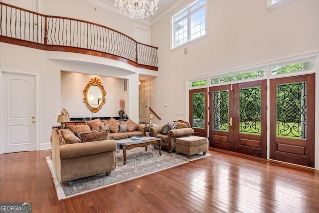 311 N Rivoli Farms Dr, Macon, GA 31210 - living room featuring a towering ceiling, a chandelier, hardwood / wood-style flooring, and crown molding