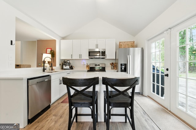 4829 Caboose Ln NW, Acworth, GA 30102 - kitchen with appliances with stainless steel finishes, light countertops, vaulted ceiling, white cabinets, and a breakfast bar area