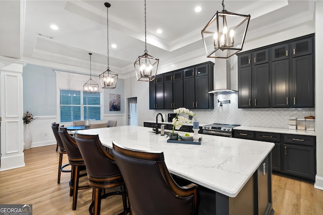 896 Bobby Jones Dr, Dublin, GA 31021 - kitchen with a tray ceiling, a chandelier, wall chimney exhaust hood, decorative backsplash, and ornamental molding
