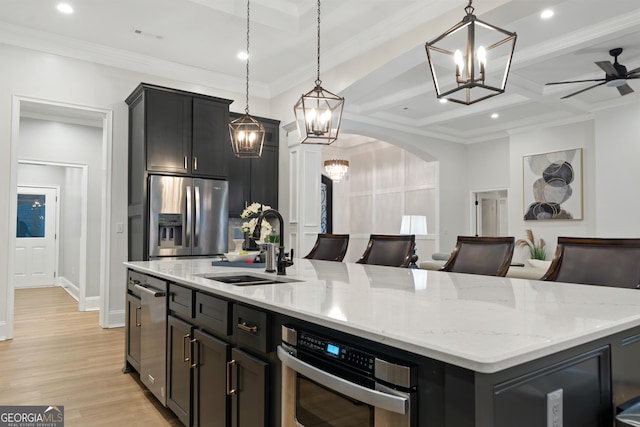 896 Bobby Jones Dr, Dublin, GA 31021 - kitchen featuring stainless steel appliances, a chandelier, a center island with sink, light wood-style flooring, and hanging light fixtures