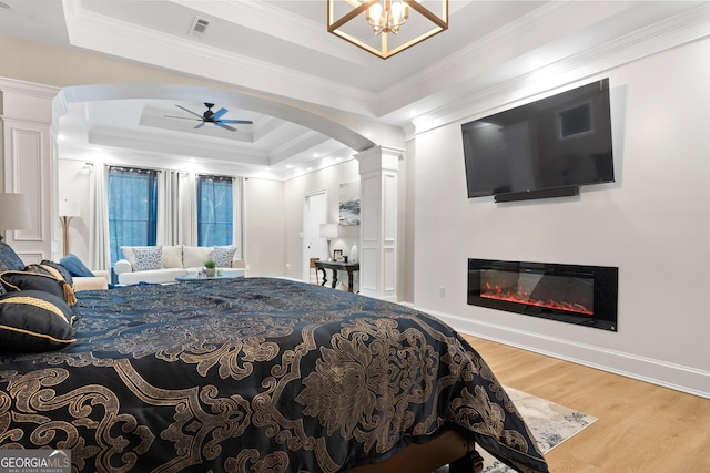896 Bobby Jones Dr, Dublin, GA 31021 - bedroom featuring arched walkways, decorative columns, a tray ceiling, wood finished floors, and ornamental molding