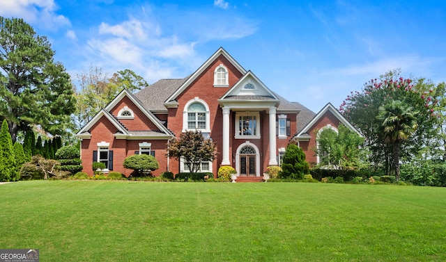 1005 Lyndhurst Way SE, Conyers, GA 30013 - greek revival inspired property with a front yard, brick siding, and french doors