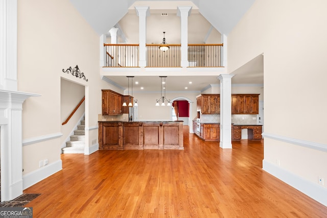 1005 Lyndhurst Way SE, Conyers, GA 30013 - unfurnished living room with a towering ceiling, light wood finished floors, arched walkways, and stairs