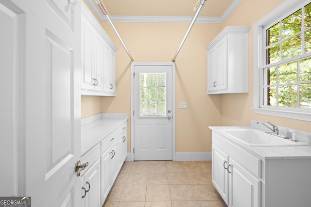 1005 Lyndhurst Way SE, Conyers, GA 30013 - laundry area with plenty of natural light, light tile patterned floors, and crown molding