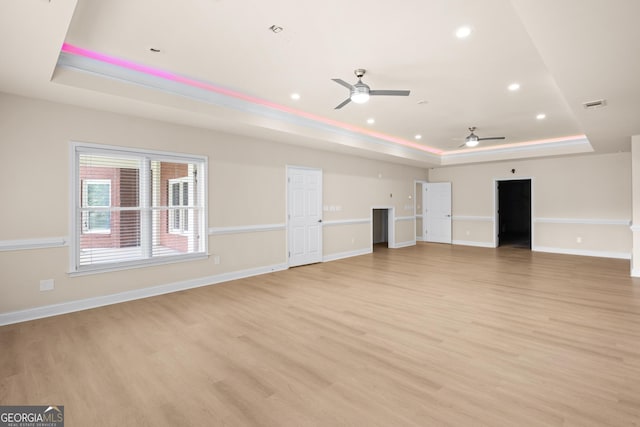 1005 Lyndhurst Way SE, Conyers, GA 30013 - unfurnished living room with a raised ceiling, ceiling fan, light wood-type flooring, and recessed lighting