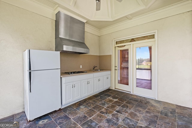 1005 Lyndhurst Way SE, Conyers, GA 30013 - kitchen featuring freestanding refrigerator, wall chimney exhaust hood, dark stone finish flooring, stainless steel gas cooktop, and crown molding
