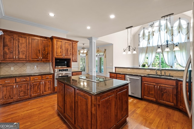 1005 Lyndhurst Way SE, Conyers, GA 30013 - kitchen with black appliances, ornate columns, a kitchen island, light wood-type flooring, and tasteful backsplash