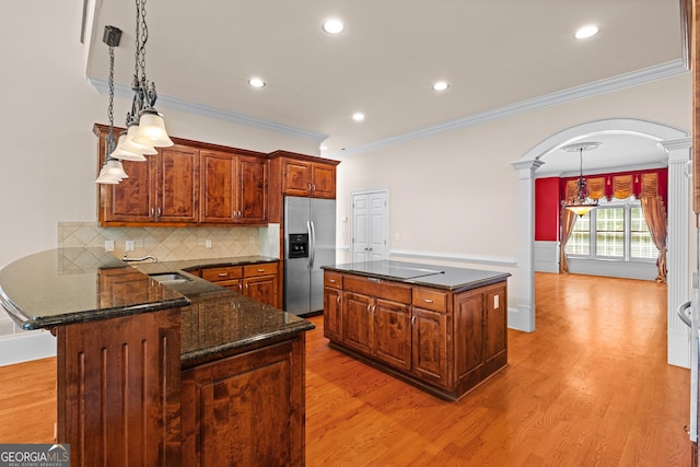 1005 Lyndhurst Way SE, Conyers, GA 30013 - kitchen featuring stainless steel fridge with ice dispenser, ornate columns, arched walkways, ornamental molding, and tasteful backsplash