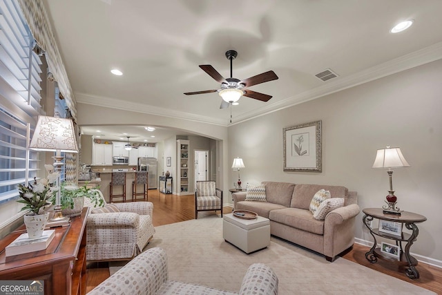 236 Creek View Ln, Acworth, GA 30102 - living room featuring ceiling fan, arched walkways, light wood finished floors, ornamental molding, and recessed lighting