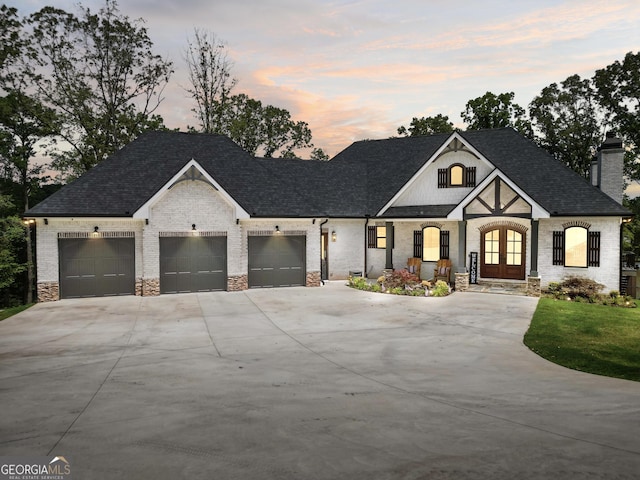 123 River Point Rd, Jackson, GA 30233 - view of front of house featuring french doors, driveway, an attached garage, a chimney, and brick siding