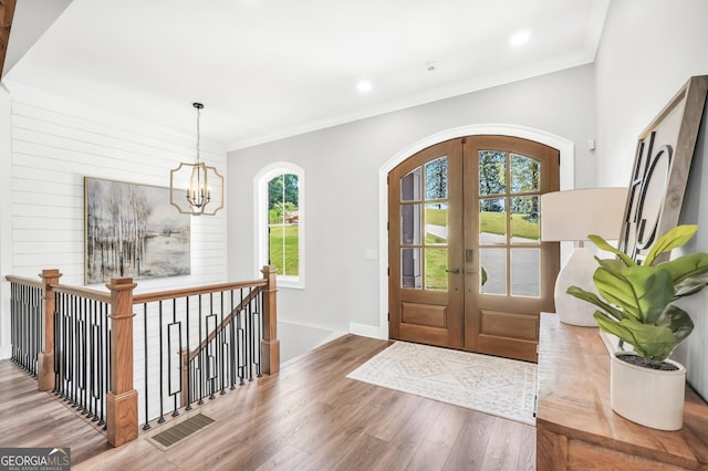 123 River Point Rd, Jackson, GA 30233 - foyer featuring french doors, wood finished floors, a chandelier, arched walkways, and ornamental molding