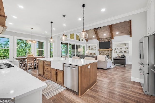 123 River Point Rd, Jackson, GA 30233 - kitchen with stainless steel dishwasher, an island with sink, high end fridge, brown cabinetry, and a stone fireplace