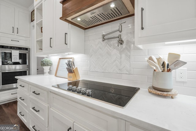 123 River Point Rd, Jackson, GA 30233 - kitchen featuring wall chimney exhaust hood, black electric cooktop, stainless steel double oven, and backsplash