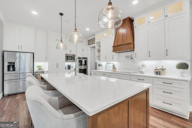 123 River Point Rd, Jackson, GA 30233 - kitchen with appliances with stainless steel finishes, premium range hood, backsplash, a center island with sink, and wood finished floors