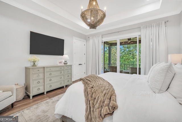 123 River Point Rd, Jackson, GA 30233 - bedroom with a tray ceiling, access to exterior, wood finished floors, and a chandelier
