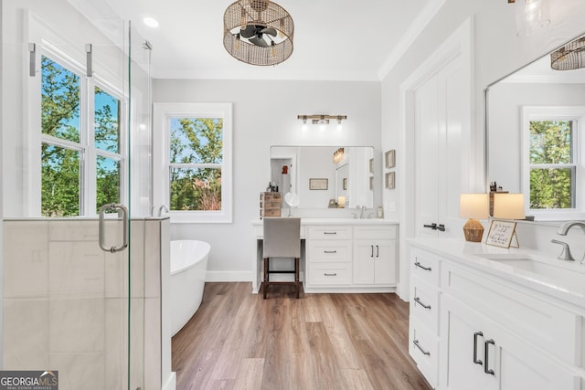123 River Point Rd, Jackson, GA 30233 - full bathroom with two vanities, a stall shower, a soaking tub, ornamental molding, and wood finished floors