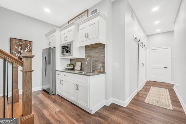 123 River Point Rd, Jackson, GA 30233 - kitchen featuring appliances with stainless steel finishes, tasteful backsplash, dark wood-style floors, white cabinets, and dark countertops