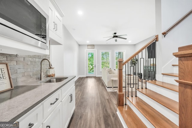 123 River Point Rd, Jackson, GA 30233 - kitchen featuring stainless steel microwave, wood finished floors, a ceiling fan, decorative backsplash, and white cabinetry