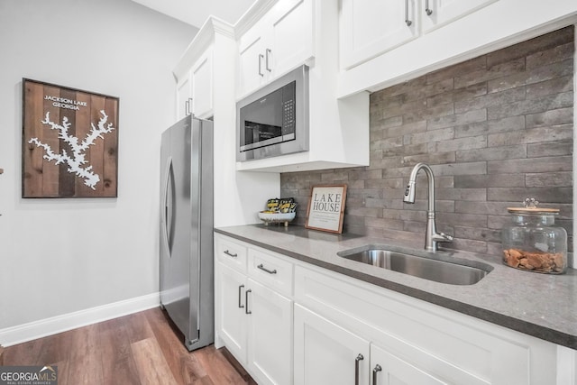 123 River Point Rd, Jackson, GA 30233 - kitchen with appliances with stainless steel finishes, tasteful backsplash, white cabinets, and dark wood finished floors