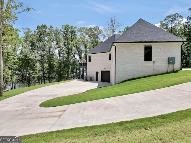 123 River Point Rd, Jackson, GA 30233 - view of side of home featuring a garage, roof with shingles, brick siding, concrete driveway, and a yard