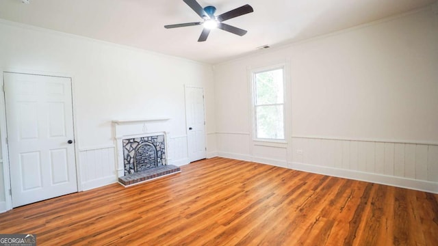 220 Confederate Ave, Dallas, GA 30132 - unfurnished living room featuring wood finished floors, ceiling fan, a fireplace, crown molding, and a wainscoted wall
