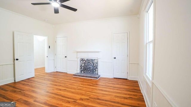 220 Confederate Ave, Dallas, GA 30132 - unfurnished living room featuring ceiling fan, crown molding, a decorative wall, wood finished floors, and a wainscoted wall