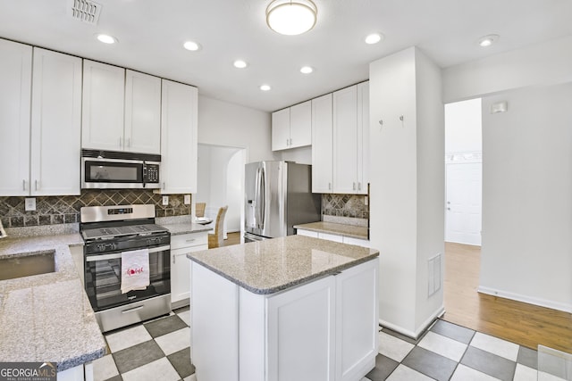 130 Sable Pointe Dr, Milton, GA 30004 - kitchen with appliances with stainless steel finishes, white cabinets, tasteful backsplash, recessed lighting, and light stone counters