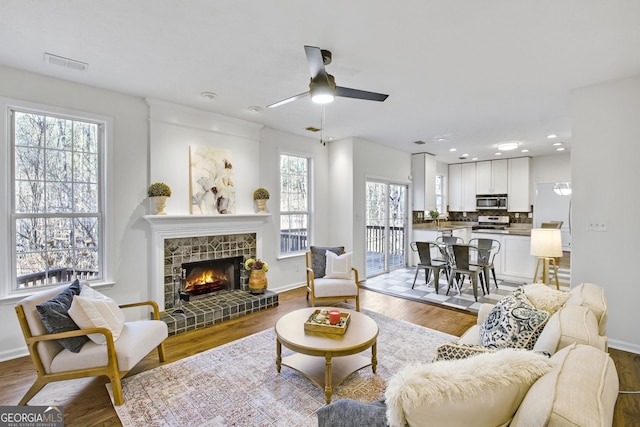 130 Sable Pointe Dr, Milton, GA 30004 - living room featuring a ceiling fan, wood finished floors, a lit fireplace, and recessed lighting