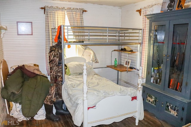 bedroom with crown molding and dark wood-type flooring