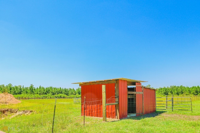 view of outdoor structure featuring a rural view and a lawn