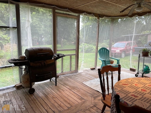 sunroom / solarium with ceiling fan and a healthy amount of sunlight