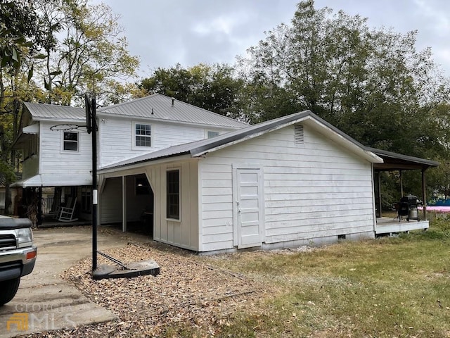 view of side of home with a lawn and a carport