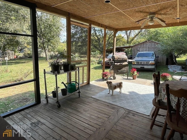 unfurnished sunroom featuring ceiling fan